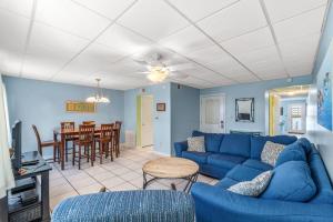 a living room with a blue couch and a table at The Treehouse On the Bay in Pensacola Beach