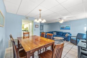 a dining room and living room with a table and chairs at The Treehouse On the Bay in Pensacola Beach +23 photos
