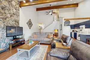 a living room with leather furniture and a stone wall at Pines 4031 in Pagosa Springs