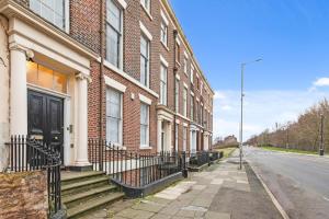 an empty street next to a brick building at Spacious 2 Bed Apartment With Secure Free Parking in Liverpool