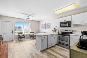 a kitchen with white appliances and a dining room at Tropical Isle #205 in Fort Walton Beach