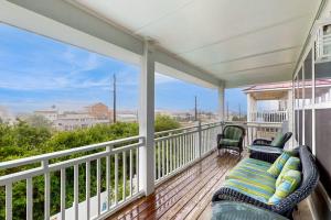 a porch with a couch and chairs on a balcony at Serenity Now in St. George Island