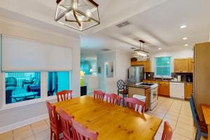 a kitchen and dining room with a wooden table and chairs at Serenity Now in St. George Island