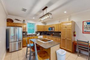 a kitchen with wooden cabinets and stainless steel appliances at Serenity Now in St. George Island +26 photos