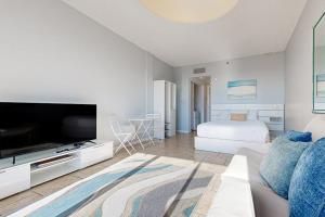 a living room with a couch and a tv and a bed at Pirates Bay B314 in Fort Walton Beach