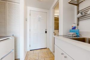 a kitchen with white walls and a white door at Pirates Bay B314 in Fort Walton Beach