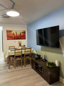 a living room with a table and a flat screen tv at Crescent Apartment - Two bedroom in Goodmayes