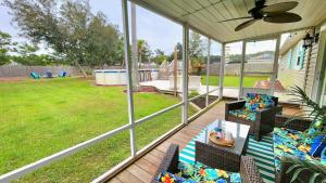 a screened in porch with a view of a yard at Poolside Palms Paradise in Navarre