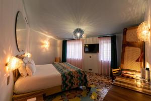 a hotel room with a bed and a mirror at L'Arlatan in Arles