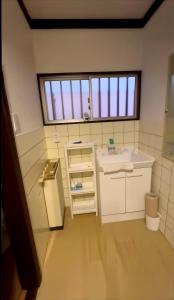 a small bathroom with a sink and a window at KIX Nest in Izumi-Sano +53 photos