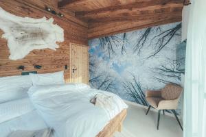 a bedroom with a large bed and a chair at Chalets Resort in Cínovec