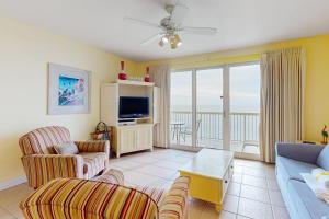 a living room with a couch and a tv at Seychelles Beach Resort 2004 in Panama City Beach