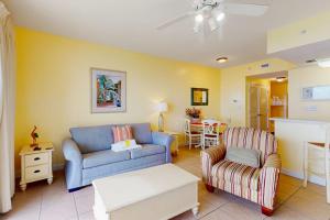a living room with a blue couch and a chair at Seychelles Beach Resort 2004 in Panama City Beach
