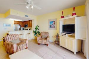 a living room with two chairs and a flat screen tv at Seychelles Beach Resort 2004 in Panama City Beach +23 photos