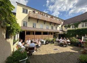 a group of people sitting on the balcony of a building at Stadthotel Drosendorf - zum Goldenen Lamm - Failler in Drosendorf Altstadt