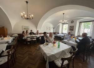 a group of people sitting at tables in a restaurant at Stadthotel Drosendorf - zum Goldenen Lamm - Failler in Drosendorf Altstadt