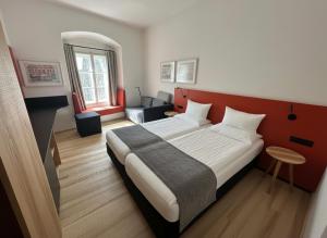 a bedroom with a large bed and a couch at Stadthotel Drosendorf - zum Goldenen Lamm - Failler in Drosendorf Altstadt