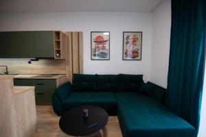 a living room with a green couch and a table at One Eleven 111 in Liptovský Mikuláš