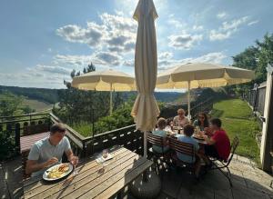 a group of people sitting at a table with a umbrella at Stadthotel Drosendorf - zum Goldenen Lamm - Failler in Drosendorf Altstadt +5 photos