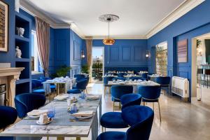 a restaurant with blue walls and tables and chairs at Estoril Boutique Hotel - Adults Only in Estoril