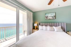 a bedroom with a bed and a balcony with the ocean at Seychelles Beach Resort 2001 in Panama City Beach