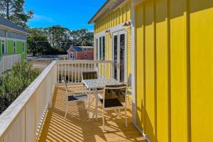 a yellow house with a table and chairs on a balcony at Sunshine Haven in Carrabelle
