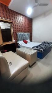 a hotel room with two beds and a couch at Hotel Savera in Rānchī