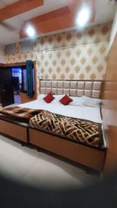 a bedroom with a large bed with white sheets and red pillows at Hotel Savera in Rānchī