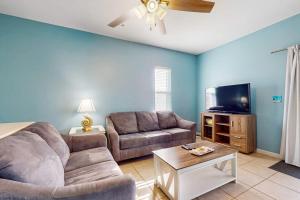 a living room with a couch and a flat screen tv at Villas on the Gulf K-2 in Pensacola Beach