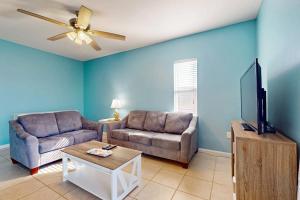 a living room with a couch and a flat screen tv at Villas on the Gulf K-2 in Pensacola Beach +19 photos