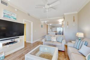 a living room with a couch and a tv at Tranquil Harbour #211 in Mexico Beach