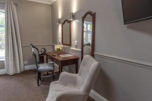 a room with a desk and two chairs and a mirror at Brackenborough Hotel, BW Signature Collection in Louth