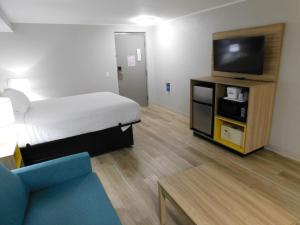 a room with a bed and a tv and a couch at Days Inn by Wyndham Effingham in Effingham