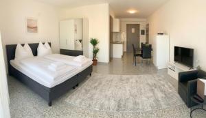 a bedroom with a large bed and a television at Pent - Aparthotel Crailsheim in Crailsheim