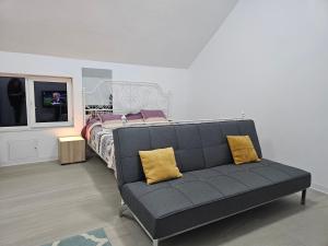 a black couch with two yellow pillows in a bedroom at Studio M in Năsăud