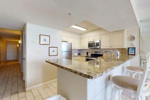 a kitchen with white cabinets and a counter top at Pelican Beach Resort 502 in Destin