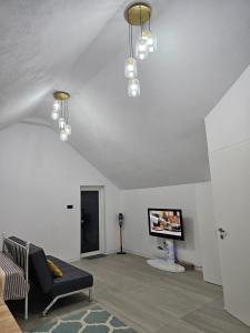 a living room with a couch and a flat screen tv at Studio M in Năsăud