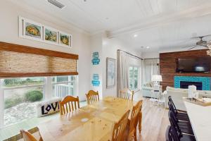 a dining room with a table and a living room at Sunset & Smiles in St. George Island