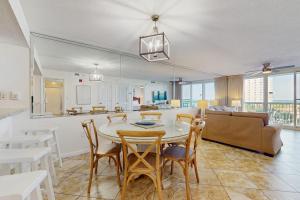 a dining room and living room with a table and chairs at Pelican Beach Resort 415 in Destin