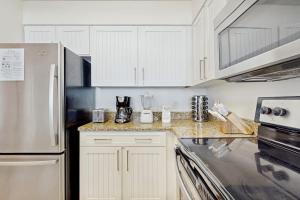 a kitchen with white cabinets and a counter top at Pelican Beach Resort 415 in Destin