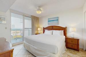 a bedroom with a large bed and a balcony at Pelican Beach Resort 415 in Destin +41 photos