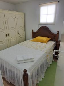 a bedroom with a bed with two white towels on it at Casa da Miquinhas II in Ponte da Barca