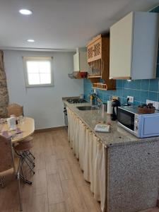 a kitchen with a sink and a counter top at Casa da Miquinhas II in Ponte da Barca +8 photos