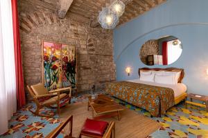a hotel room with a bed and a chair at L'Arlatan in Arles +32 photos