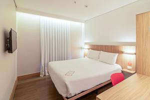 a bedroom with a large white bed and red chairs at Hotel Moov Porto Alegre in Porto Alegre +43 photos