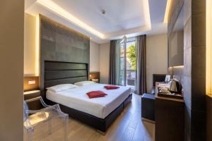 a hotel room with a large bed and a window at UNAHOTELS Villa dei Platani Foligno in Foligno +109 photos