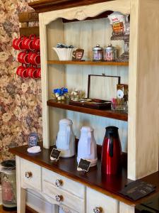 a cupboard with two coffee makers on top of it at Red Rose Inn Bed and Breakfast in Bardstown