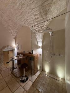 a bathroom with a shower and a desk and a table at La Piazzetta - Luxury Homes in Ceglie Messapica