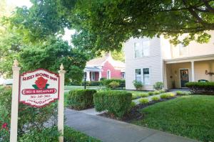 a house with a sign in front of a yard at Red Rose Inn Bed and Breakfast in Bardstown