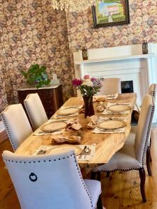a dining room with a wooden table and chairs at Red Rose Inn Bed and Breakfast in Bardstown